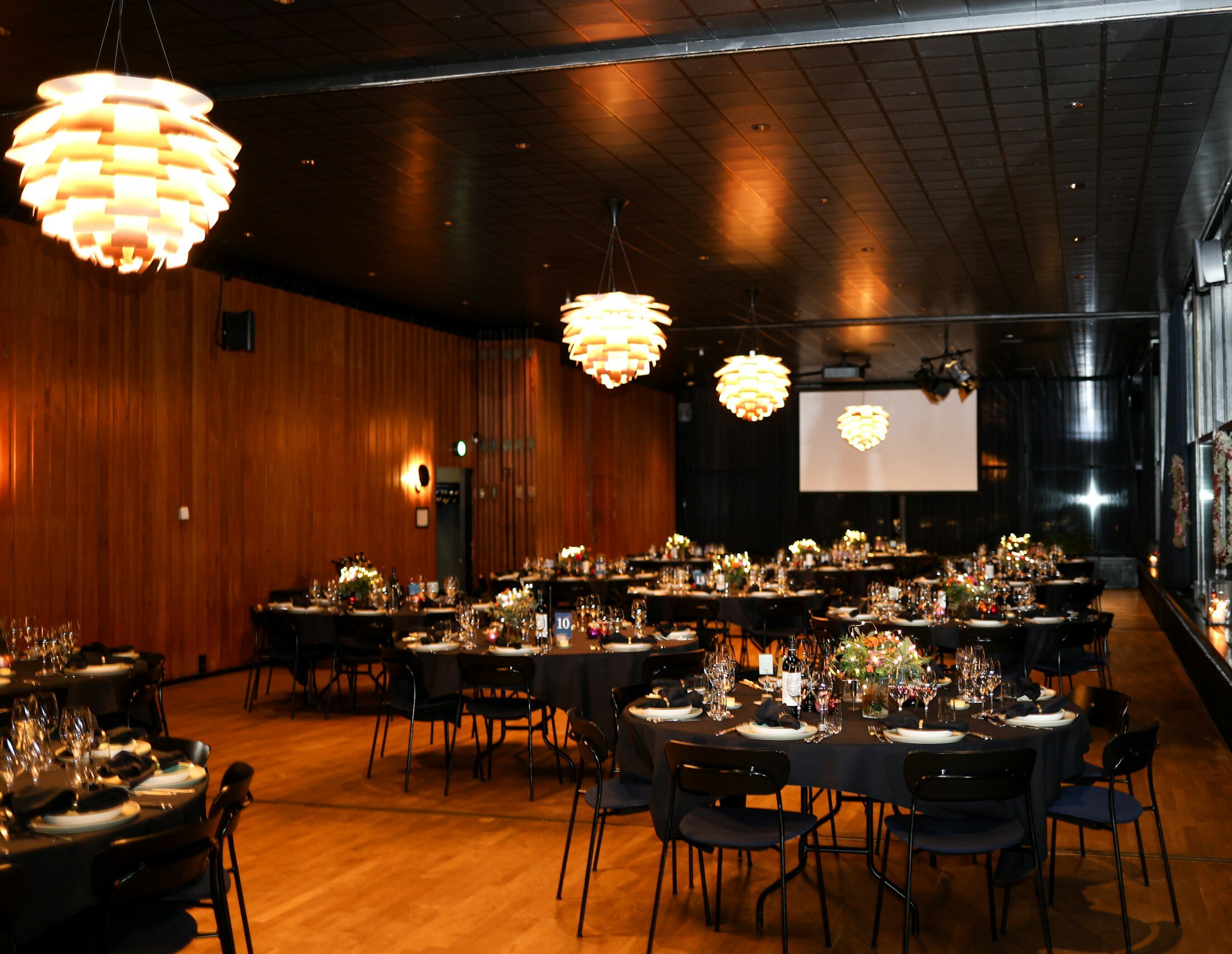Dîner de gala, lumière chaude & tables noires — Réception d’entreprise